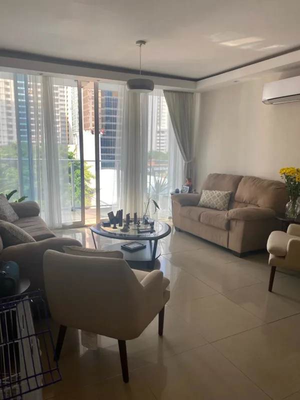 Contemporary living room with beige sofas, large windows, balcony access at luxury PH The Palm apartment Obarrio Panama City.