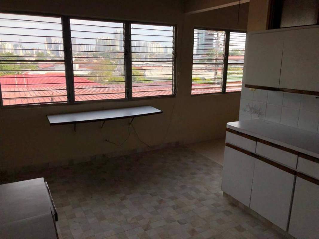 Simple kitchen with large windows overlooking skyline, tiled counters in Betania Panama house