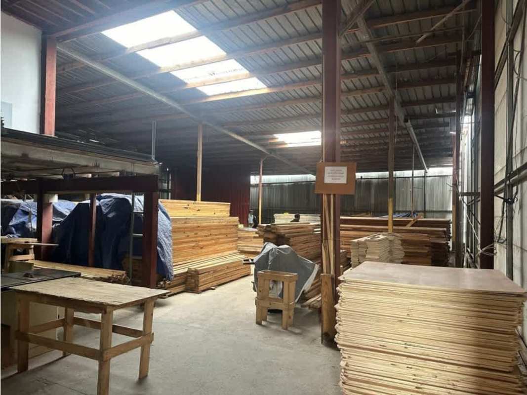 Industrial warehouse with skylights, stacks of lumber, workspace inside Llano Bonito Panama