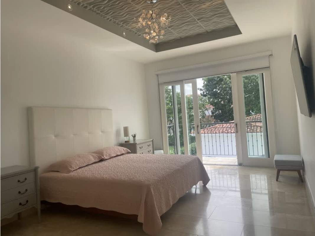 Modern home office with glass desk, wooden cabinets and large window in luxury property Santa Maria Panama