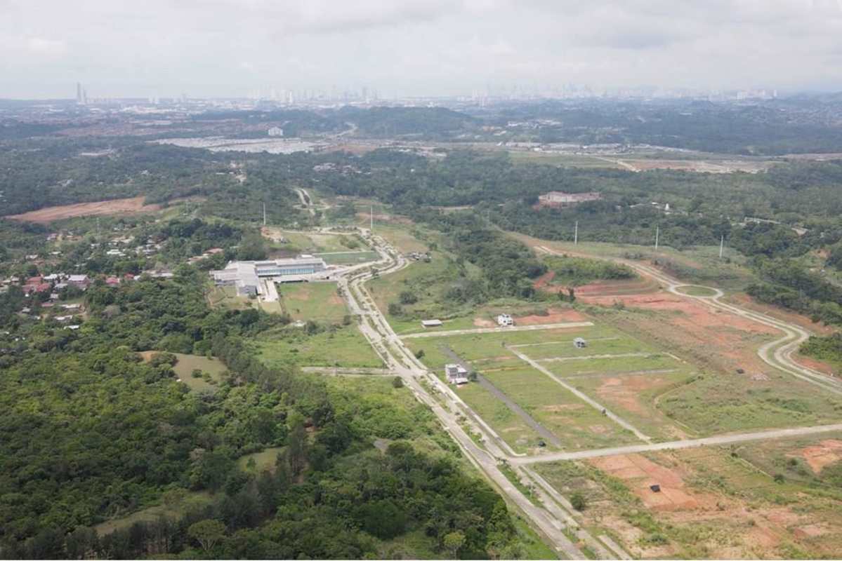 Large aerial showing open plots, paved streets, greenery in Green Valley Panama