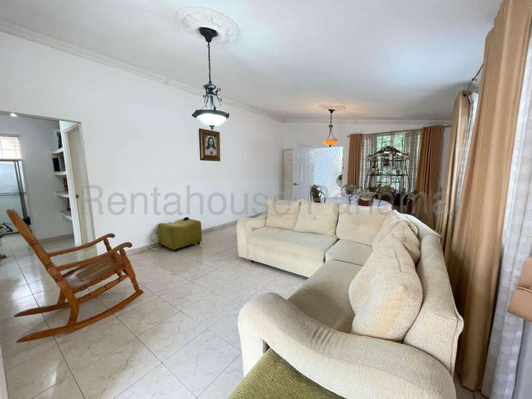 Traditional living and dining room with large windows and ceramic floors in Panama City home