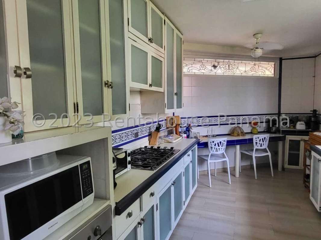 Bright ceramic-tiled kitchen with cabinetry and gas stove in El Carmen Panama City