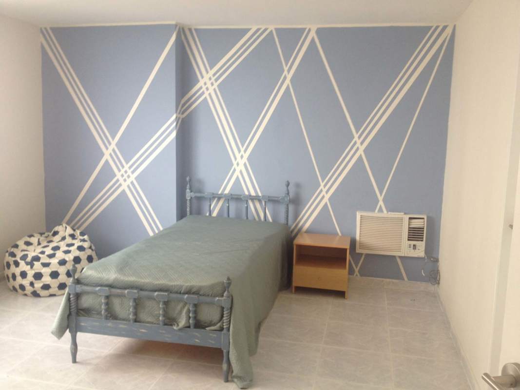 Bedroom featuring large window, study desk, bookshelf, minimalist decor at PH Vista del Mar Panama