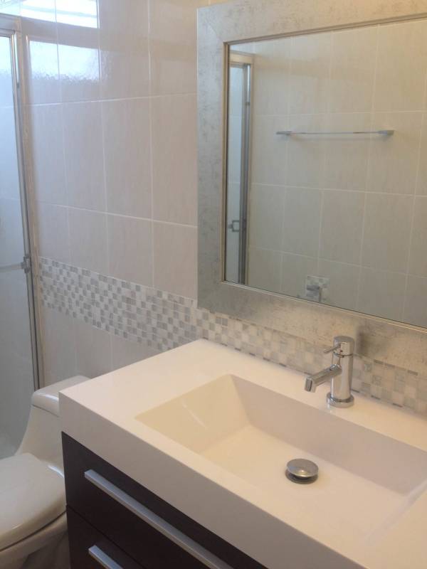 Minimalist bedroom with blue accent wall, window AC and closet in PH Vista del Mar Avenida Balboa Panama