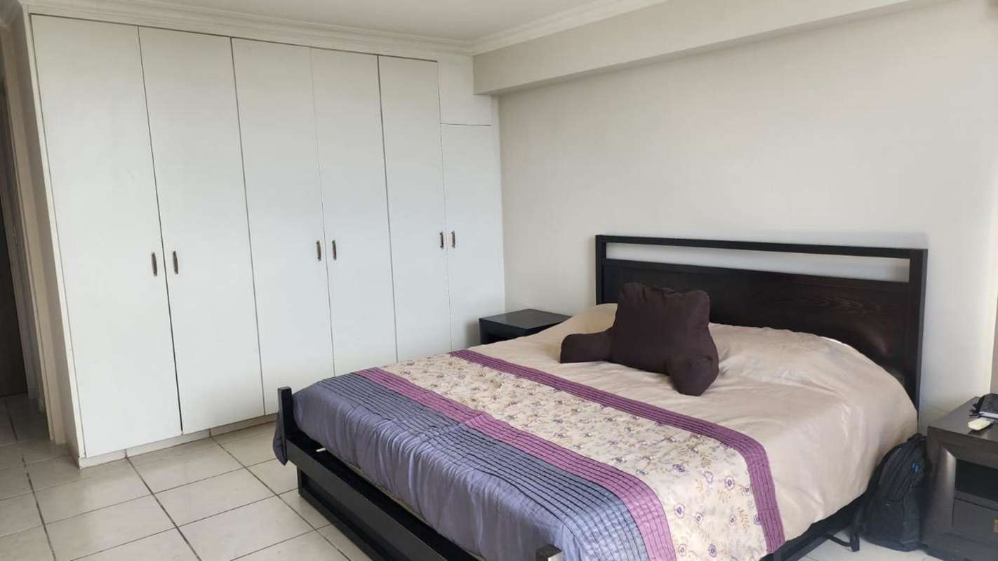 Bedroom with large window city skyline view vertical blinds split AC in Villa de las Fuentes Panama
