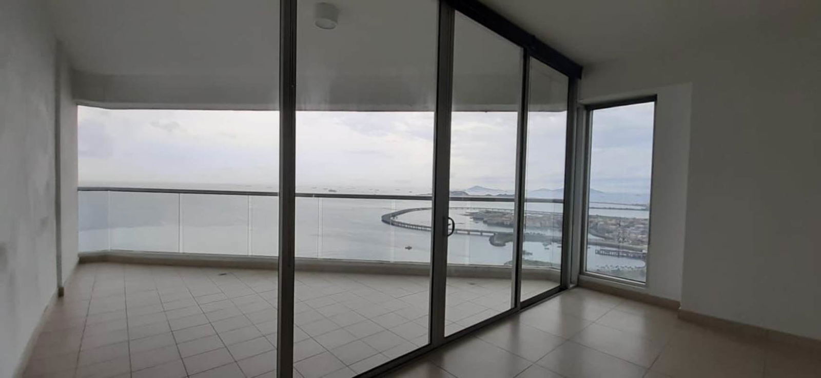 Bright living area with floor-to-ceiling windows and oceanfront balcony at PH Rivage