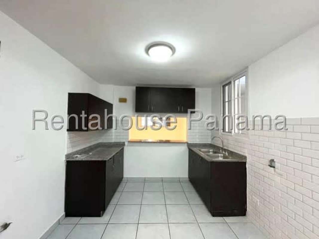 Kitchen with white tile backsplash dark wood cabinets dual sinks ceramic floors Condado del Rey