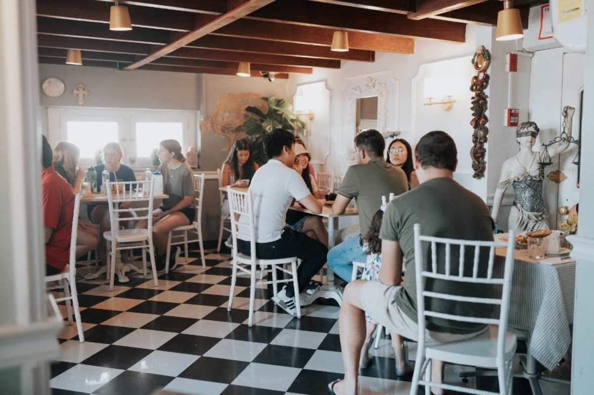Elegant dining lounge with checkered floor, exposed wood beams and mirror accents Casco Viejo Panama