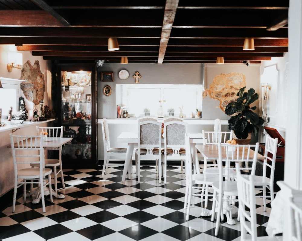 Rustic dining space with tile floor, beams, eclectic decor in Casco Viejo Panama cafe