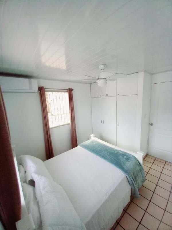 Bedroom with built-in closet, ceiling fan, white walls in Condado del Rey Panama City
