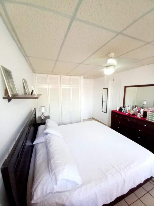 Spacious bedroom with king bed, wardrobes, ceiling fan and tiled floor in Condado del Rey house
