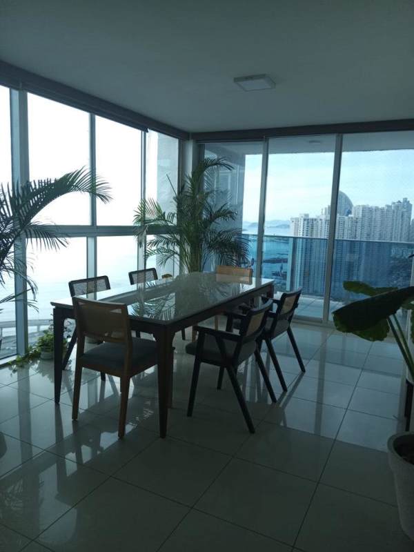Bright dining area with panoramic floor-to-ceiling glass featuring ocean and skyline views at PH Waterfalls Panama City