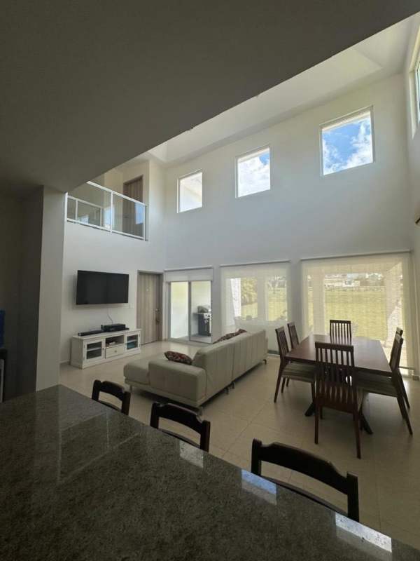 Double-height living dining room with sectional sofa, bright windows Bijao Beach house rental Panama