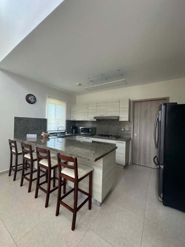 Open kitchen with granite counters, bar seating, appliances Bijao Beach House Panama