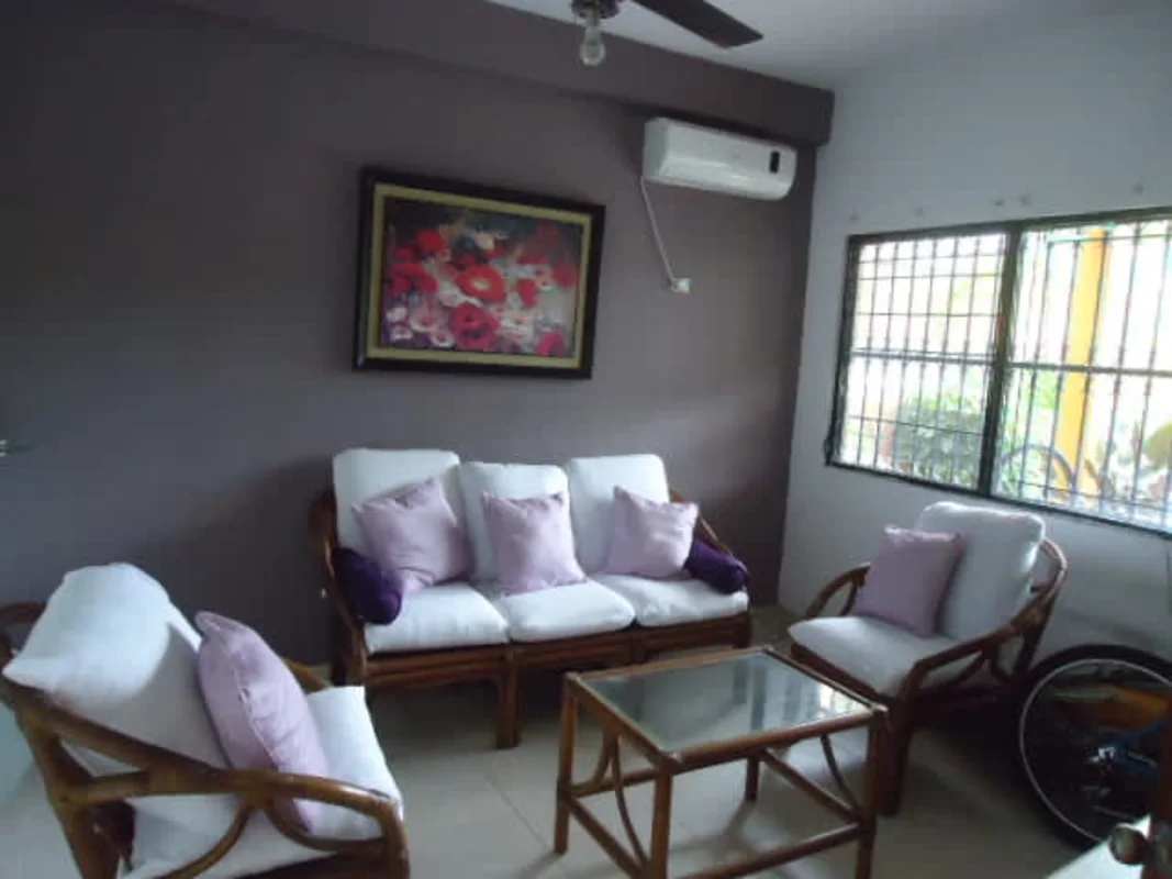Elegant living room with striped sofa, tiled floors, wall art in Dos Mares house Panama City