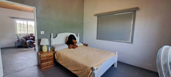 Bedroom with large window, closet space, wooden ceiling and fan in El Higo home Panama