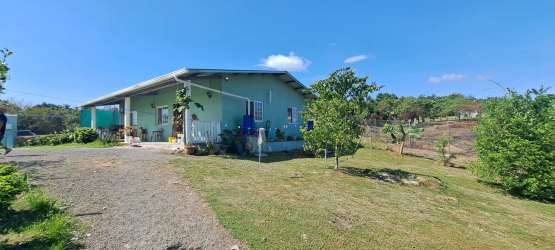 Rustic kitchen with wooden countertops, island, large windows, tile backsplash in country house El Higo Panama