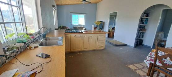 Modern bathroom with wooden countertop vanity, glass block divider, window lighting in rural house Panama