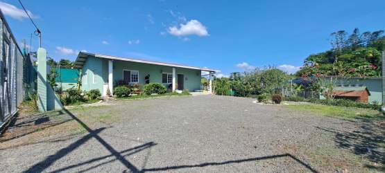 Open plan living room with wood plank ceiling, windows, natural light in cozy home El Higo San Carlos Panama