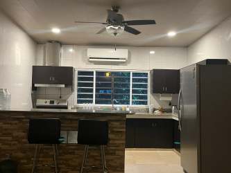 Kitchen with breakfast bar, stainless appliances, and cabinetry in country house Las Uvas San Carlos Panama