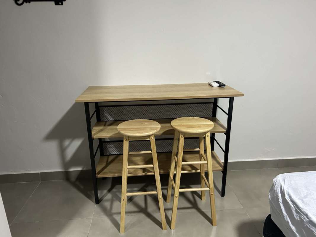 Living space with bar-style dining area and minimalist design in studio Tocumen Panama