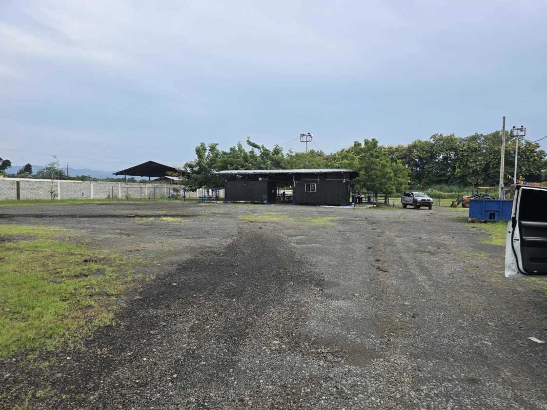 Gated commercial lot with blue fencing, gravel surface and covered shelter Pacora Panama