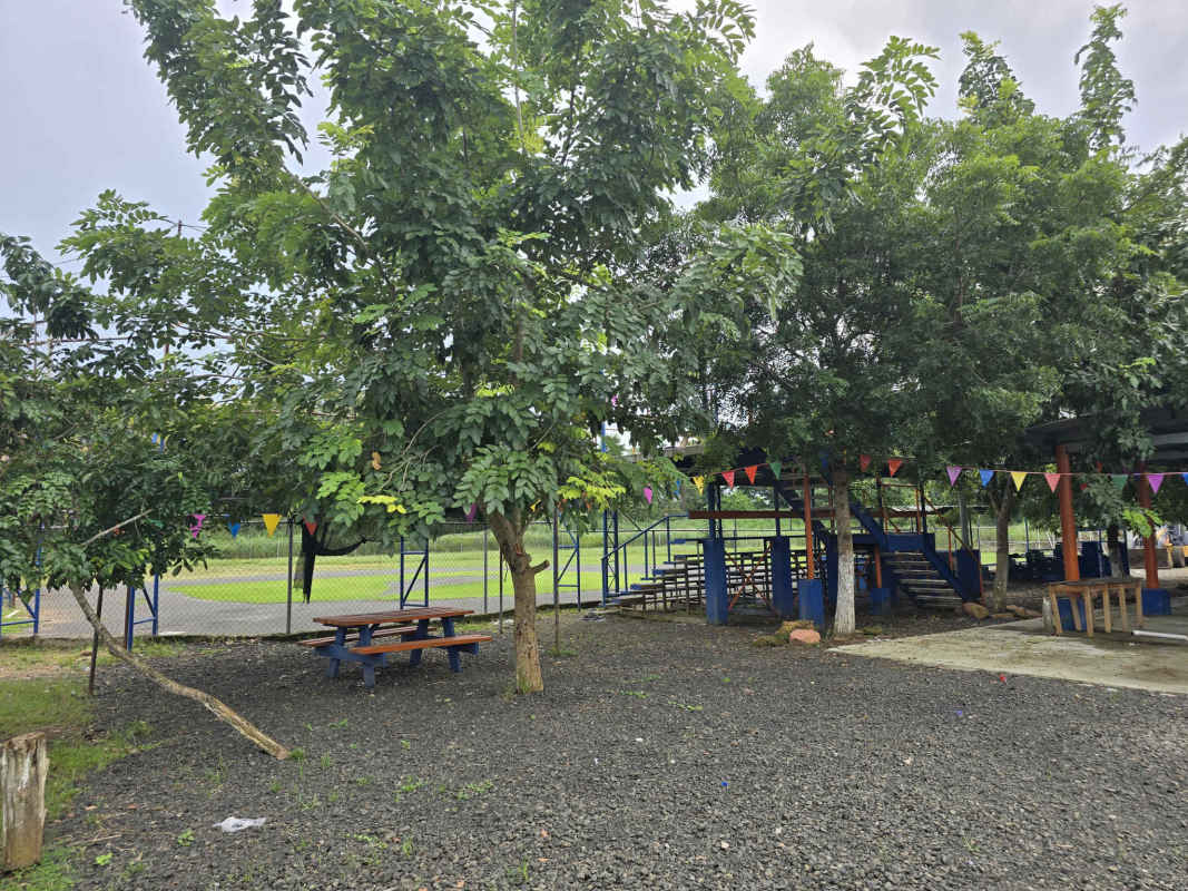 Shaded playground with colorful flags, picnic tables Pacora Panama land