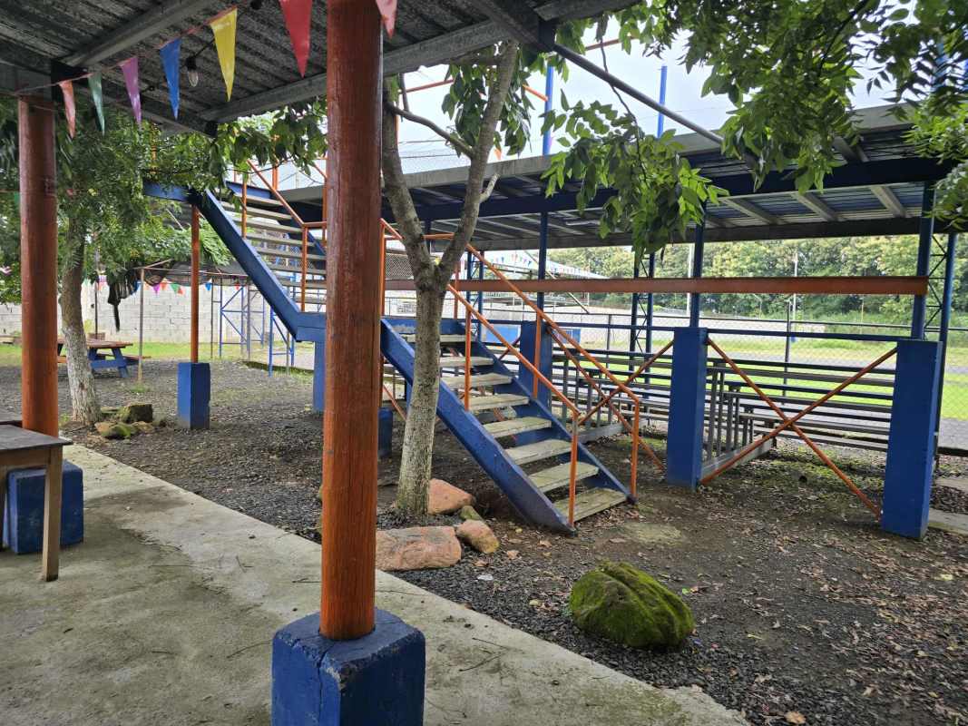 Covered bleachers and shaded event gathering space with colorful flags Pacora