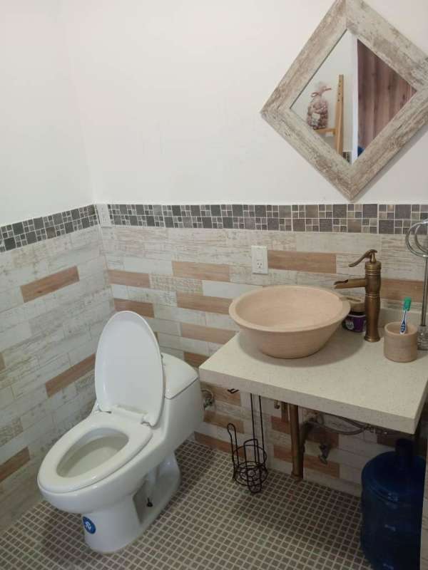 Modern bathroom with vessel sink and mosaic tiles, rustic mirror in Chanis studio Panama