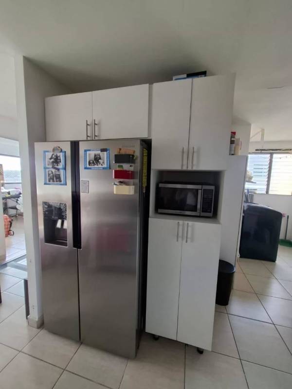 Modern kitchen with stainless refrigerator and white cabinetry in PH Parque de Versalles Panama City