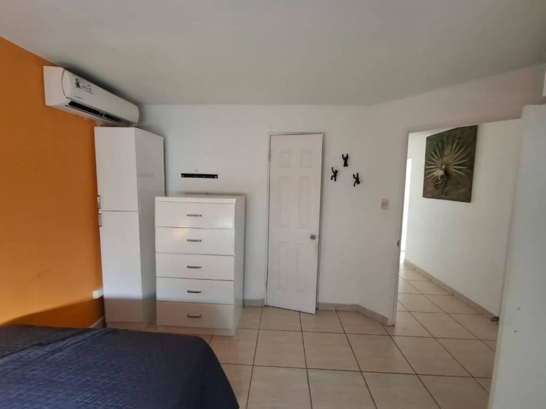 Master bedroom with tile floors and built-in closet at PH Parque de Versalles in Chanis Panama