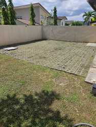 Private backyard paved and with green lawn at modern home in Panama Pacifico community