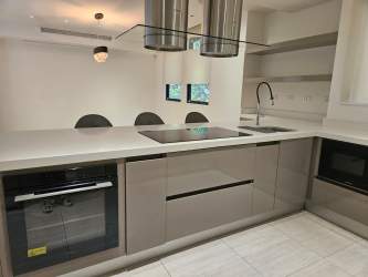 Kitchen with built-in stainless appliances, granite counters, modern cabinets in Panama Pacifico home