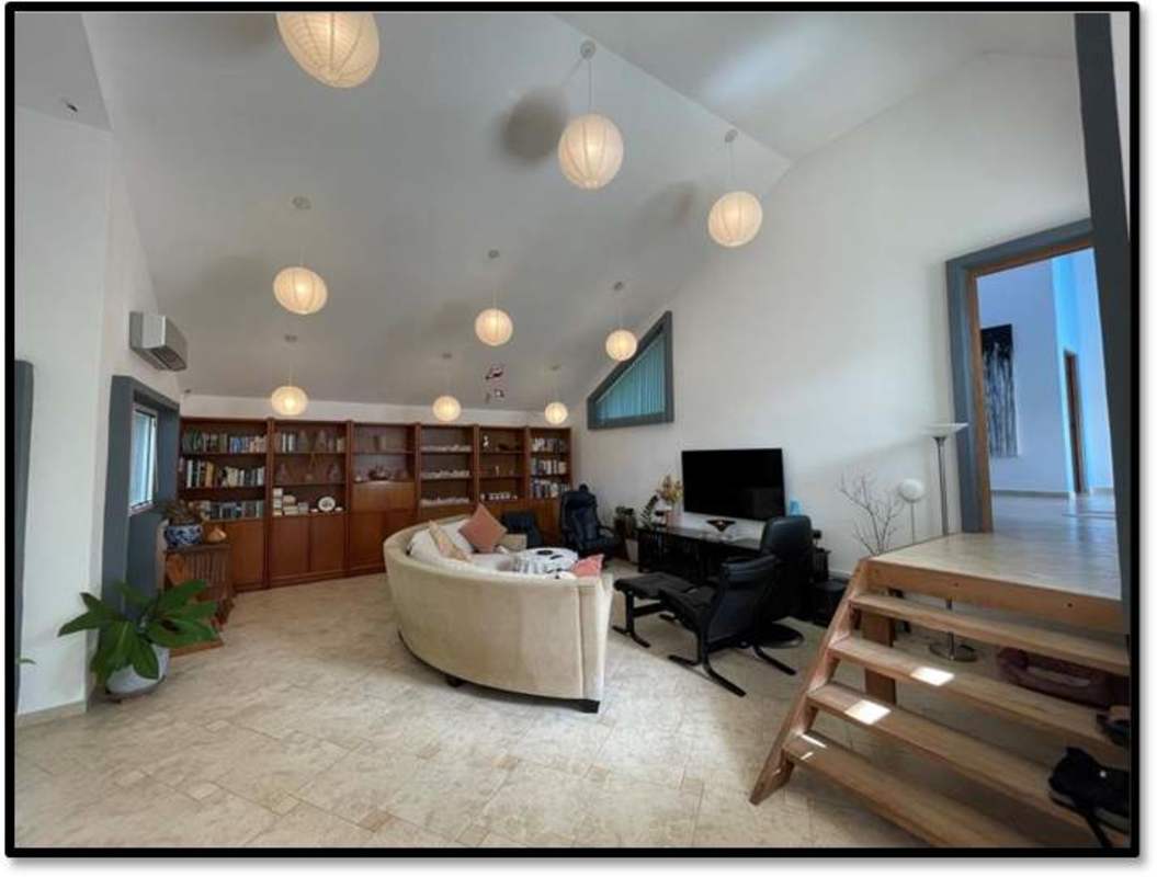 Vaulted ceiling living area with pendant lights, built-in bookshelves in Clayton family home Panama