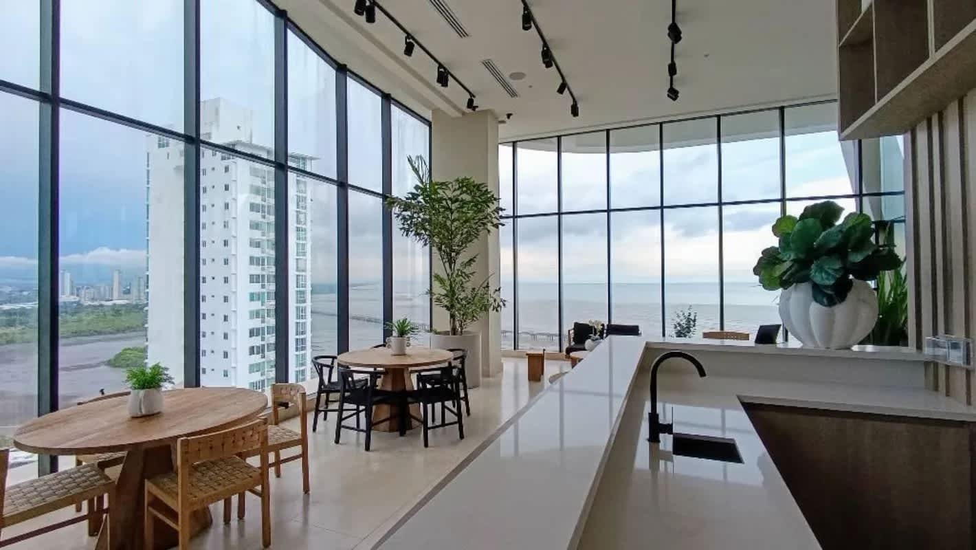 Open living dining room with floor-to-ceiling ocean view windows in luxury apartment Panama City