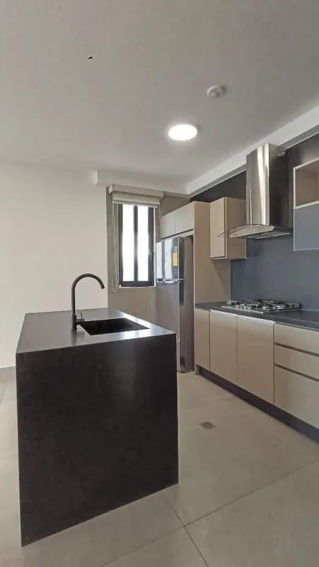 Sleek kitchen with island, appliances, quartz counters in Victory Wellness apartment Panama