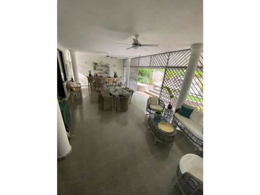 Covered patio terrace with outdoor furniture and garden view in Loma Alegre house Panama