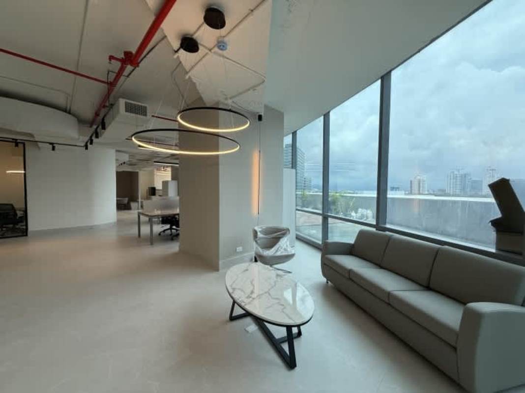 Office lounge area with city views, modern lighting and furniture at PH Prisma Business Tower Costa del Este Panama