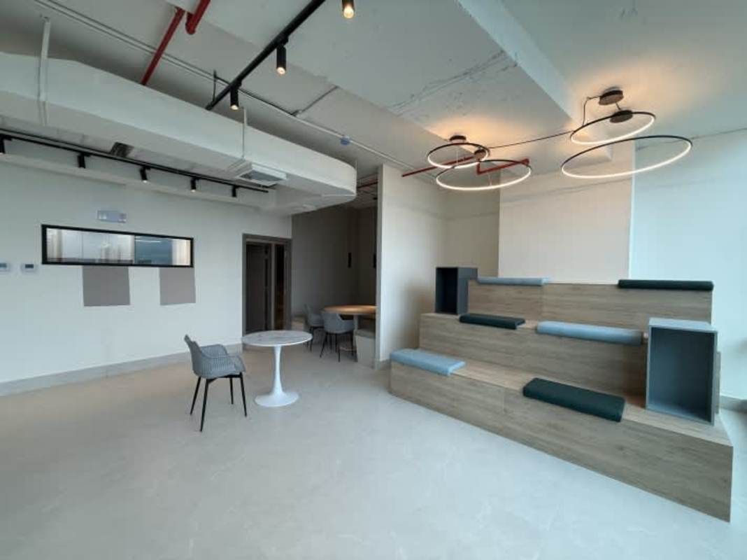 Collaborative lounge with tiered wood seating, pendant lights at PH Prisma Business Tower Costa del Este Panama