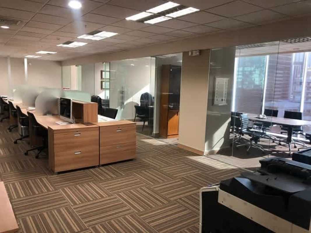 Open office floor plan with cubicles glass partitions striped carpet Office One Tower Obarrio Panama