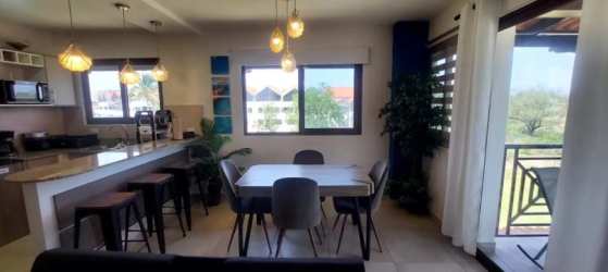 Modern open kitchen with breakfast bar and dining area in beach condo PH Coronado Golf Panama