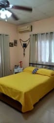 Bedroom with two single beds, pink bedding, tiled floors in Penonomé Coclé Panama
