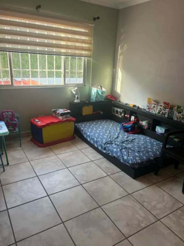 Kids bedroom with colorful shelving, large window, tile floor in duplex Brisas del Golf Panama