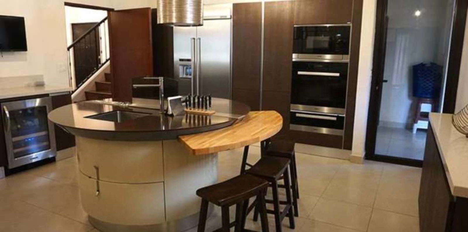 Foyer with wooden stairs, chandelier, console table, wall mirror luxury Clayton villa Panama
