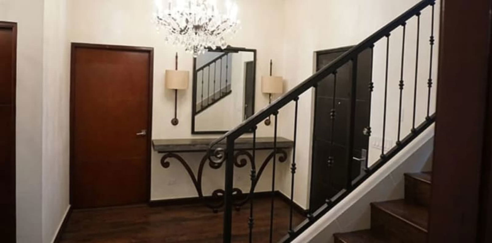 Bedroom featuring chandelier, large window with patterned curtains, wood furniture in Clayton Panama