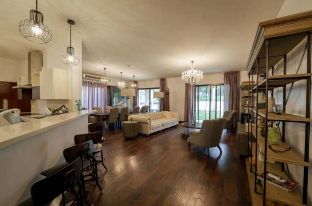 Elegant open plan living-dining with cream sofa set, chandelier, piano and decor in Clayton villa Panama