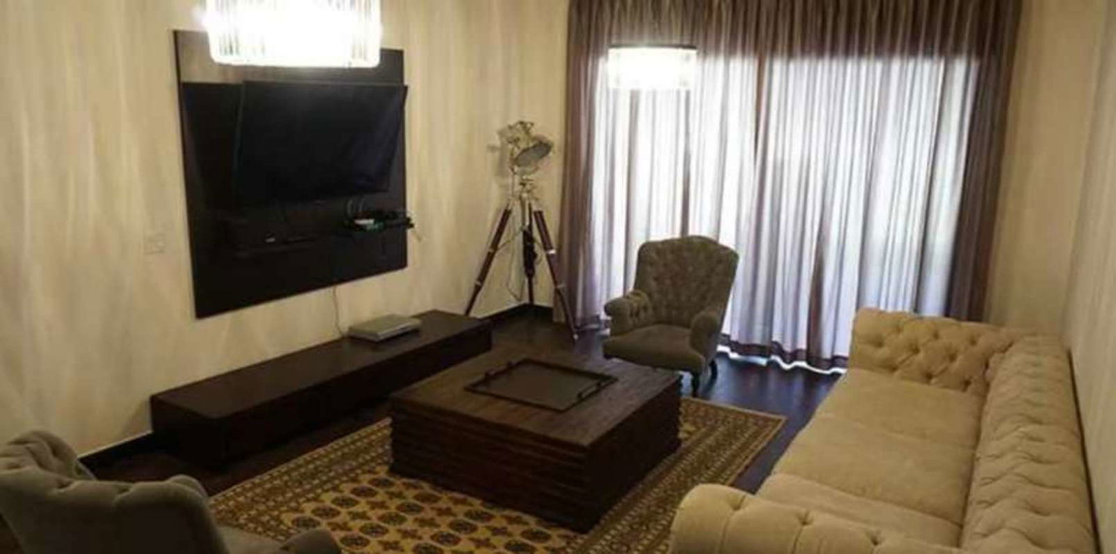 Spacious master bedroom with balcony access, chandelier, large bed, wood flooring in luxury villa Panama