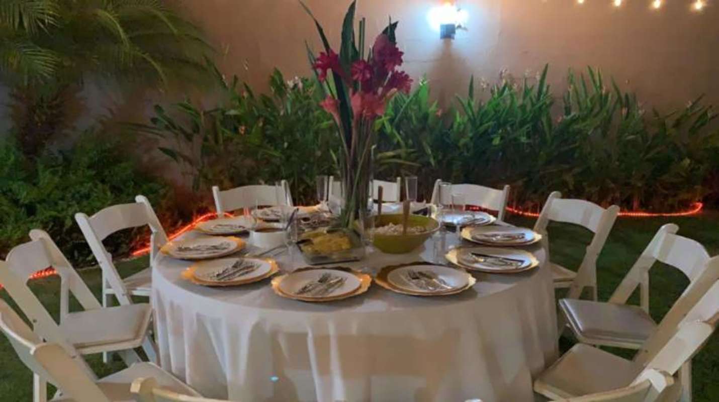 Outdoor dining patio with green garden, string lights at PH Versalles Panama