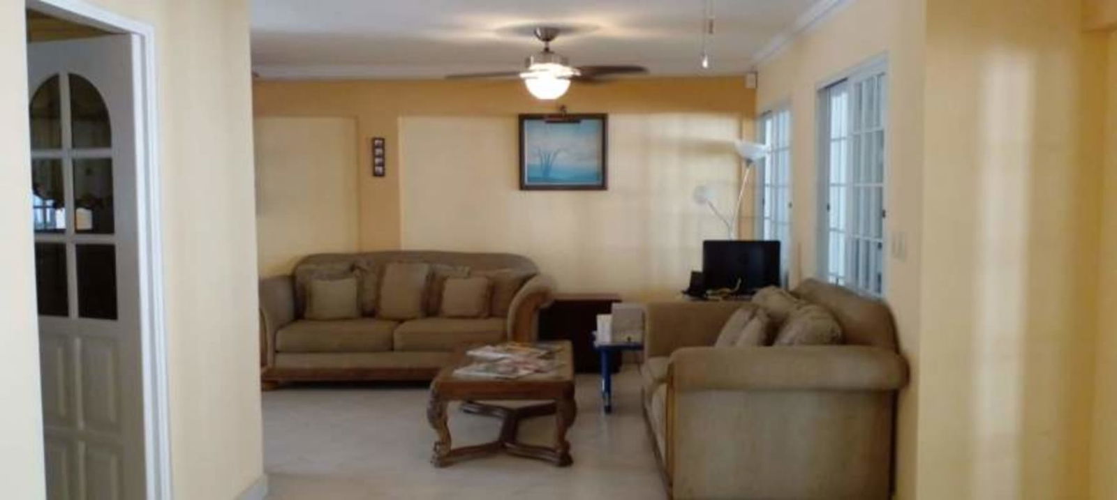 Kitchen with cream cabinets, granite counters, central island, floral curtains Miraflores Panama